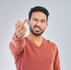 Image showing Rude, middle finger and portrait of asian man in studio for fail, conflict and problem. Annoyed, upset and aggressive with male and hand gesture on gray background for hate, disrespect and furious