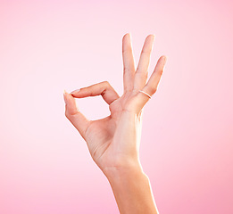 Image showing Hand, perfect and ok sign or emoji in studio for motivation, review and yes or agreement for support. Woman icon, gesture or fingers for approval, communication or decision on mockup pink background