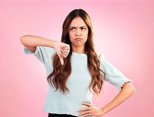 Image showing Sad, hands and thumbs down by woman in studio for bad review, complaint or disappointed on pink background. Frown, finger and emoji expression by girl with vote for wrong, bad news or reject isolated