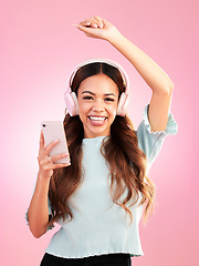 Image showing Music headphones, phone and portrait of woman in studio isolated on a pink background. Smile, radio dance and happy female with mobile streaming, enjoying and listening to audio, sound or podcast.