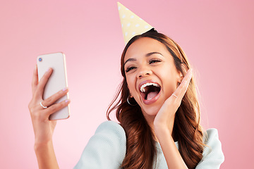 Image showing Birthday, selfie and excited with a woman in studio on a pink background for the celebration of an event. Phone, social media and party with an attractive young female celebrating a special occasion