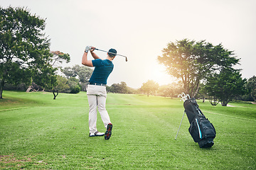 Image showing Golf, stroke and training with a sports man swinging a club on a field or course for recreation and fun. Golfing, grass and hobby with a male golfer playing a game on a green during summer