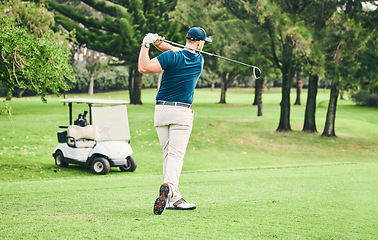 Image showing Golf, stroke and grass with a sports man swinging a club on a field or course for recreation and fun. Golfing, hobby and training with a male golfer playing a game on a green during summer