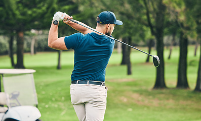 Image showing Golf, training and hobby with a sports man swinging a club on a field or course for recreation and fun. Golfing, grass and stroke with a male golfer playing a game on a green during summer