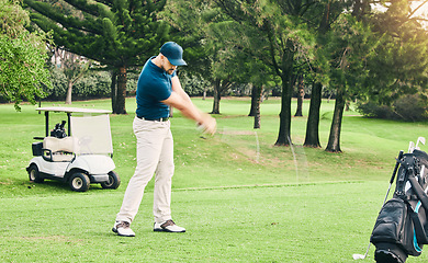 Image showing Golf, stroke and hobby with a sports man swinging a club on a field or course for recreation and fun. Golfing, grass and training with a male golfer playing a game on a green during summer