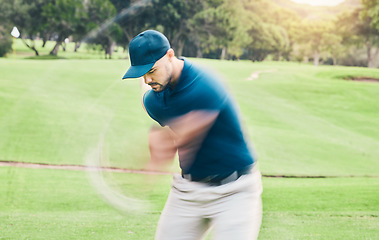 Image showing Golf, motion blur and hobby with a sports man swinging a club on a field or course for recreation and fun. Golfing, grass and training with a male golfer playing a game on a green during summer