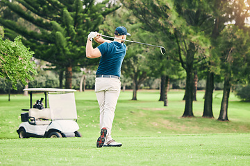 Image showing Golf, stroke and focus with a sports man swinging a club on a field or course for recreation and fun. Golfing, grass and training with a male golfer playing a game on a green during summer