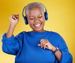 Image showing Music, headphones and black woman dance in studio isolated on a yellow background. Podcast, radio and happy African female streaming, enjoying and listening to audio, sound track or song for dancing.