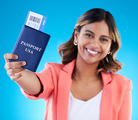 Image showing Happy woman face show passport isolated on blue background for USA travel opportunity, immigration or holiday. Identity document, flight ticket and excited portrait of young indian person in studio