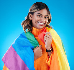 Image showing Portrait, pride flag and woman with smile, support and queer against a blue studio background. Face, happy female and lady with equality, symbol for lgbtq community and transgender with human rights