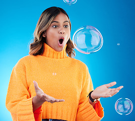 Image showing Surprise, shock and bubble with indian woman in studio for soap, positive and satisfaction. Magic, creative and holding with female isolated on blue background for bright, cute and entertainment