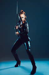 Image showing Woman, warrior and vigilante in cosplay with sword stance for battle, war or game against dark studio background. Female in black widow costume standing ready with blade for halloween or hunger games