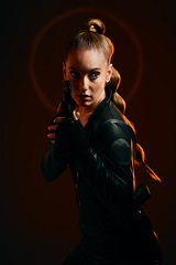 Image showing Woman, warrior and gun to fight in studio for action and safety from danger on dark background. Strong female model, assassin or agent in scifi cosplay costume with weapon for action and defense