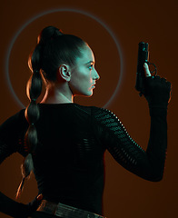 Image showing Dark, assassin and a woman with a gun for action isolated on a studio background. Mission, warrior and a mafia agent with a weapon for protection, security and combat on a backdrop for a fight