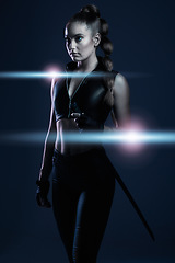 Image showing Woman, sword and assassin in studio with costume, action or cyberpunk fashion in suit. Girl, blade and leather fashion for crime, danger and futuristic spy with danger or future aesthetic with ninja