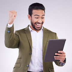 Image showing Success, winning and man on tablet isolated on studio background fist pump for business news or online bonus. Happy asian person or winner on digital tech with celebration for sale, prize or giveaway