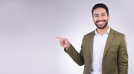 Image showing Happy businessman, pointing and mockup for product placement, marketing or advertising against a white studio background. Employee man with smile showing point of advertisement, news or notification