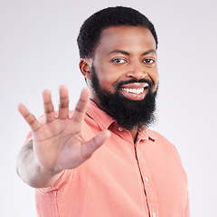 Image showing Black man, hand and stop in studio portrait with smile, sign language and communication by background. Young african model, signal or symbol for opinion, protest palm and voice with confident pride