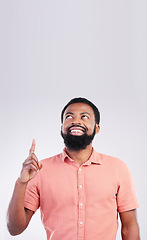 Image showing Point, mockup space and black man looking up with hand gesture for product placement, advertising and sign. Happy, studio and male smile on white background pointing for choice, branding and showing