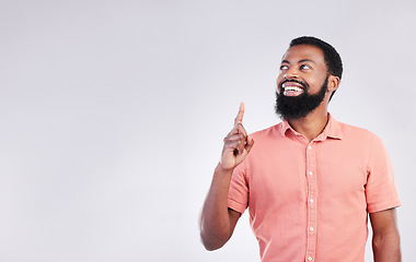 Image showing Point, studio and black man with mockup space and hand gesture for product placement, advertising and sign. Happy, smile and male thinking on white background pointing up for choice, branding or show