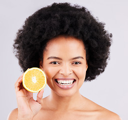 Image showing Portrait, skincare and orange by black woman in studio for vitamin c, wellness or skin on white background. Face, fruit and girl model excited for citrus treatment, cosmetic or anti aging beauty