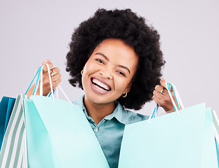 Image showing Shopping bag, studio portrait and happy black woman with luxury sales product, designer fashion deal or mall store present. Commerce market, discount gift and retail customer face on gray background