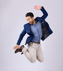 Image showing Businessman, excited and jumping in studio with happy smile with winning expression on white background. Freedom, success and jump, Indian man with energy and motivation in celebration of winner deal