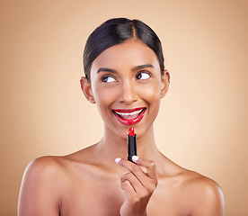 Image showing Makeup, red lipstick and beauty of a woman in studio for cosmetics, face glow and shine product. Indian female model thinking on beige background about skin, facial self care and lips with color idea