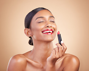 Image showing Beauty, makeup and woman with lipstick, dermatology and happiness against a brown studio background. Happy, female and lady with cosmetics, aesthetic and confidence with grooming, red gloss and smile