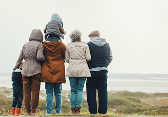 Image showing Family hiking outdoor, generations at beach together with nature view and back, spending quality time in winter. Grandparents, parents and children, love and care with people at the coast