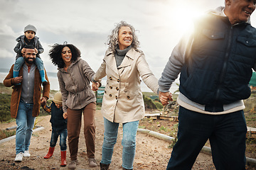 Image showing Family, travel and adventure outdoor holding hands with children, parents and grandparents with flare. Men, women and kids walking together in nature with support, happiness and care for bonding time