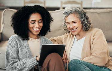 Image showing Senior woman, tablet and tech teaching with a mixed race female in a living room showing a app. Family, happiness and home with people watching and streaming a video on technology with a smile