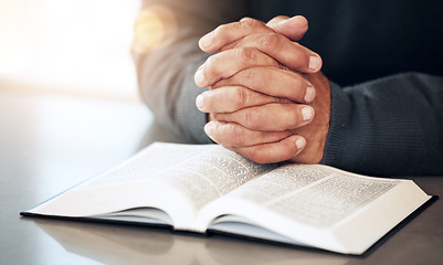 Image showing Bible, hands and prayer of a man reading christian text for spiritual healing and religion. Lens flare, hand closeup and praying of a person with peace and a book for praise, support and hope