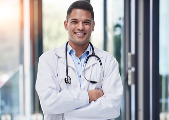 Image showing Portrait, man and happy doctor with arms crossed, stethoscope and confident surgeon in hospital. Proud young healthcare worker smile in lab coat, medical services and surgery trust in wellness clinic