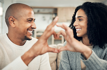 Image showing Happy, love and hand heart by couple on sofa with love, care and trust at home together. Emoji, shape and man with woman hands in support of hope, marriage and unity, smile and joy in living room