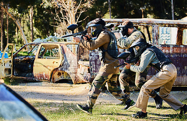 Image showing Team, paintball and army moving on the attack in extreme adrenaline sport, battle or war in the nature outdoors. Group of people soldiers walking or aiming down sights in teamwork sports engagement