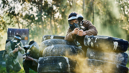 Image showing Team, paintball and tires for cover bunker or protection while firing or aiming down sights together in nature. Group of people waiting in teamwork for opportunity to attack or shoot in extreme sport