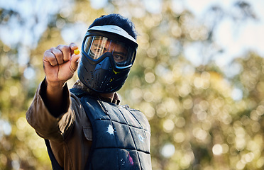 Image showing Man, paintball and hands holding ball on the battlefield for war, shot or engaging act in nature. Male paintballer or soldier showing or pinching paint bullet in military or extreme adrenaline sports