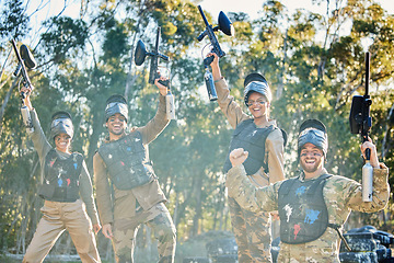 Image showing Team, paintball and portrait in celebration for winning, victory or achievement on the battlefield together in nature. Group of people enjoying win, success or teamwork with guns in the air for sport