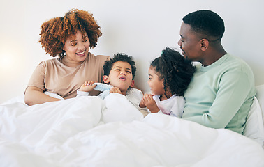 Image showing Happy, love and parents with children in bed enjoy morning for bonding, quality time and relaxing. Black family, bedroom and mother, father and kids playing on holiday, weekend and vacation at home