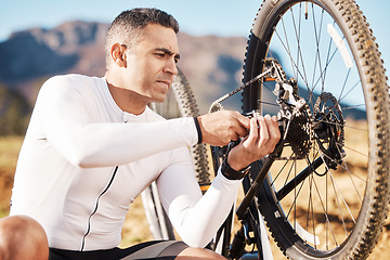 Image showing Cycling, repair and wheel with man and focus for sports, wellness and fitness training. Insurance, safety and tire change with cyclist fixing mountain bike on trail for broken, puncture and check