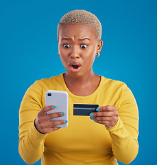 Image showing Credit card, phone and woman shocked for online shopping mistake, transaction fail or debt isolated on blue background. Wow, surprise and stress person for fintech payment mistake on mobile in studio