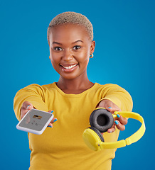 Image showing Music, sharing and phone with portrait of black woman in studio for streaming, giving and multimedia for you. Podcast, mobile radio and technology with female on blue background for headphones audio