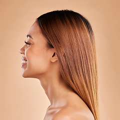 Image showing Woman, beauty and hair care profile with a smile for growth and shine shampoo on a brown background. Aesthetic female happy in studio for natural keratin treatment and wellness with color and texture
