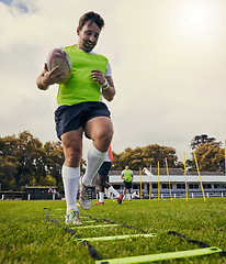 Image showing Rugby, sports and man training on field with equipment ready for match, practice and sport games. Fitness, performance and happy male athlete running for warm up, exercise and workout for competition