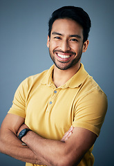 Image showing Portrait, smile and Asian man with arms crossed, confidence and relax on a blue studio background. Face, Japanese male and guy with leadership, casual fashion outfit and success with joy and cheerful