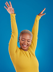 Image showing Black woman, happy and freedom celebration in studio with a smile of a winner with hands raised. African female celebrate freedom, energy dance and mindset winning prize or lottery on blue background