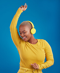 Image showing Black woman with headphones, dancing and listening to music, rhythm and fun with freedom on blue background. Happy female with yellow aesthetic, streaming radio with dance and carefree in studio