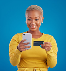 Image showing Online shopping, credit card and black woman with phone in studio for ecommerce on blue background. Debit, fintech app and girl with subscription, membership or budget, payment and banking