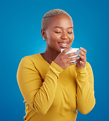 Image showing Black woman, happy and coffee or tea smell in studio with a smile and happiness. African female model with a drink and hands on cup to relax with a positive mindset on blue background with beauty